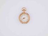 a close up of a gold pocket watch on a white surface