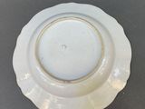 a white plate with a gold rim sitting on a table