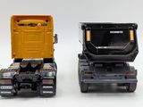 two toy trucks sitting side by side on a white surface