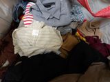 a pile of clothes that is on a bed
