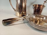 a silver plate with a spoon and a cup on the table