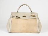 un sac à main en cuir blanc et beige avec des finitions dorées