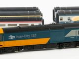 three model trains sitting side by side on a white surface