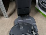 a black and gray robot sitting on the floor next to a box