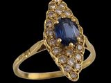 a close up of a gold ring with a sapphire and diamonds