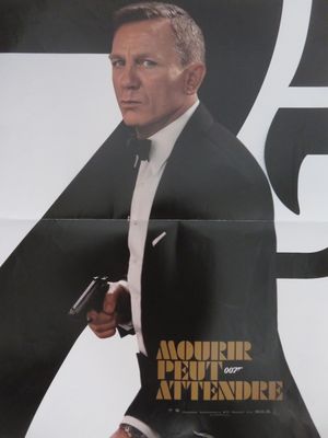 une affiche représentant un homme en costume tenant une arme à feu