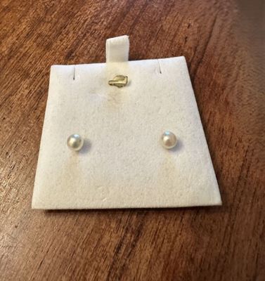 a close up of a pair of earrings on a wooden table