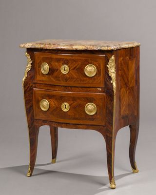 an antique chest of drawers with a marble top