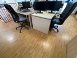 a desk with two computer monitors and a chair