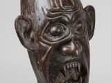 a close up of a wooden sculpture of a man ' s face
