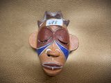 a mask on the wall with a tag on it