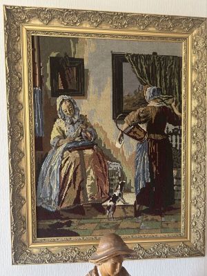 une statue représentant un homme et une femme assis devant un tableau
