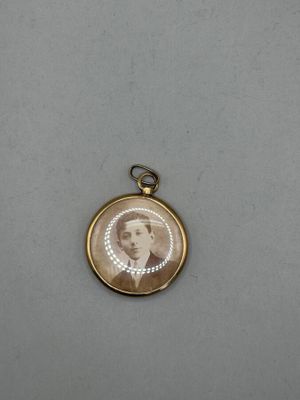 an antique photo of a man in a suit and tie is shown in a gold locke