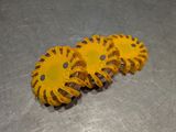 three yellow gears sitting on a metal surface