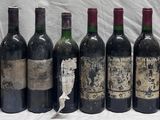 several bottles of wine are lined up in a row on a table