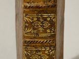 a gold book that is sitting on a white surface