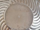 a silver plate with a circular design on top of it