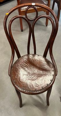 une chaise en bois avec une assise marron dans une pièce