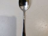 a spoon with a spoon handle hanging on a wall