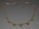 une image représentant un collier en or orné de feuilles