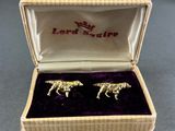 a close up of a pair of gold horse cufflinks in a box
