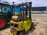a yellow forklift truck parked next to a green tractor