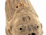 an old wooden mask on a white surface with a white background