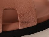 the bottom of a pair of brown sandals with black soles on a white surface