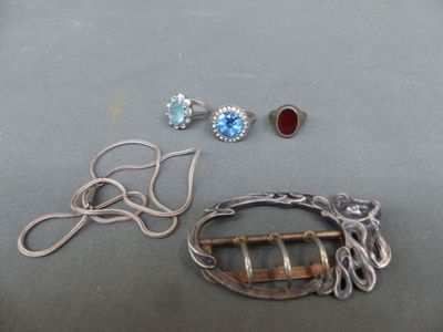 two pairs of earrings and a broochet are sitting on a table