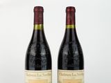 deux bouteilles de vin rouge posées l'une à côté de l'autre sur une surface blanche