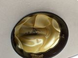a white cowboy hat with a gold ribbon around the brim