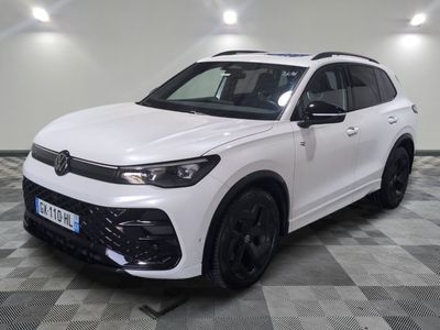 un SUV Volkswagen blanc garé sur un sol à damier dans un garage