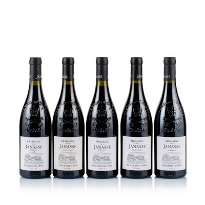 four bottles of wine are lined up on a white surface