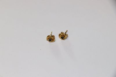 une paire de boucles d'oreilles en or sur un fond blanc