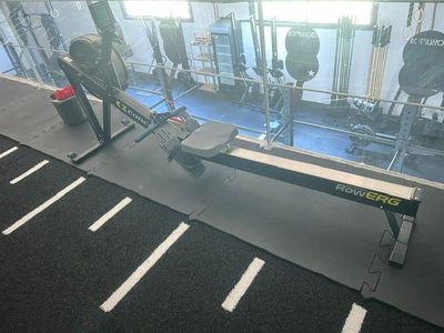 une photo d'une salle de sport avec une rangée d'appareils