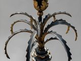 a black and gold vase with a plant inside of it