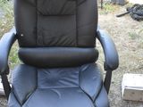 une chaise de bureau noire posée dans l'herbe