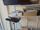un tabouret noir posé devant une étagère remplie de cartons