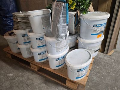 de nombreux seaux de peinture posés sur une palette