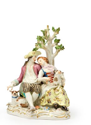 une figurine représentant un homme et une femme assis sous un arbre