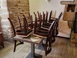 des tables et des chaises dans une pièce aux murs en pierre et au sol en bois