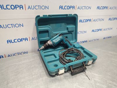 une perceuse électrique dans une mallette bleue avec un cordon à l'intérieur