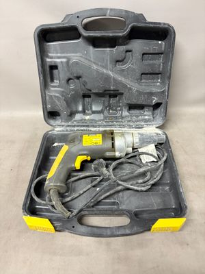 an electric drill in a black case with a cord