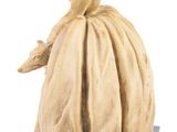 statue of a woman in a dress sitting on a stone block
