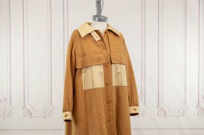 une photo d'un manteau posé sur un pied de mannequin dans une pièce