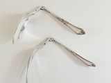 two spoons that are sitting on a white surface