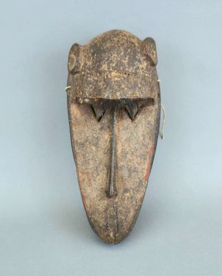 gros plan d'un masque en bois sur une surface blanche