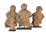 trois figurines représentant trois personnes accompagnées d'un chien, posées sur un socle
