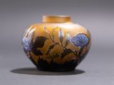 a yellow vase with blue flowers on it sitting on a table