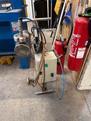 un extincteur posé à côté d'une borne d'incendie dans un garage